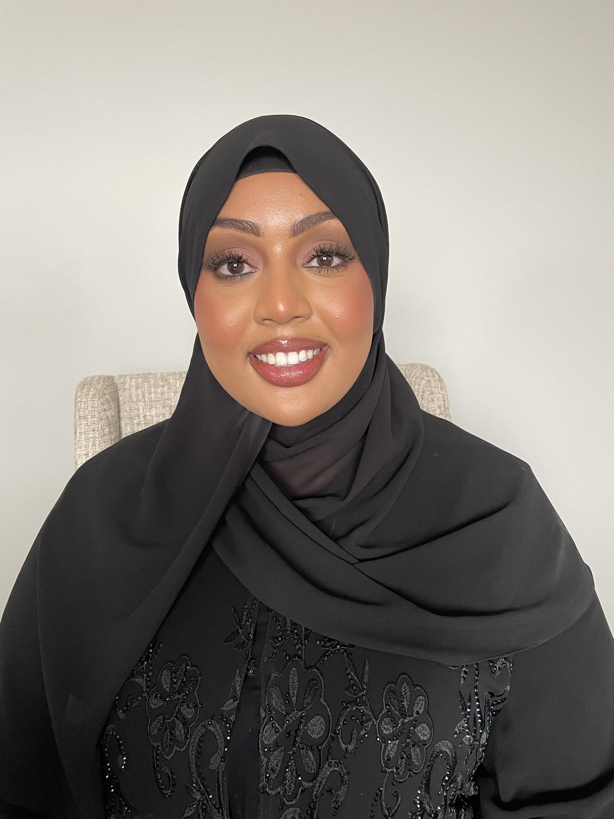 Client in black hijab with radiant soft glam